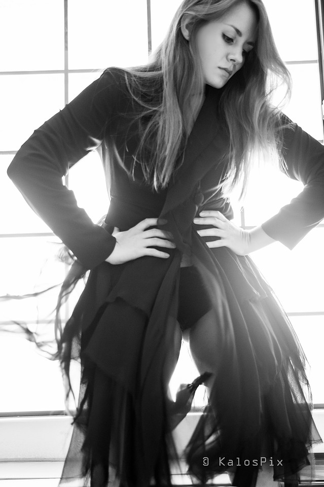 Backlit black and white editorial portrait, flowing dark dress